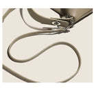 Close-up of a beige pebbled leather handbag strap with silver-tone hardware