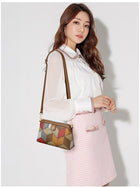 Woman wearing a white blouse and pink skirt carrying a geometric patterned shoulder bag.