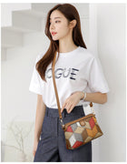 Woman wearing a white t-shirt and blue trousers carrying a geometric patterned crossbody bag