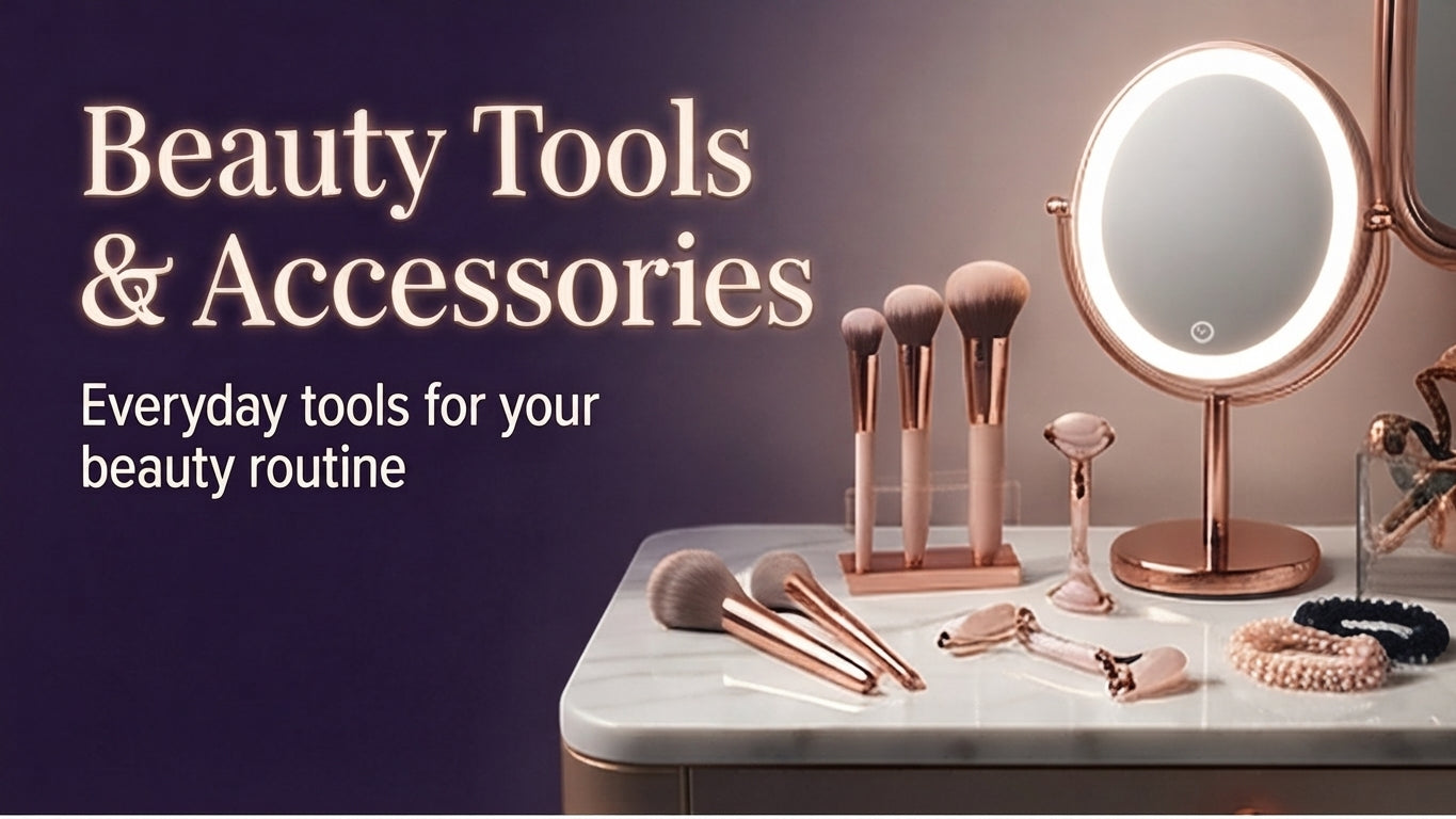Set of rose gold beauty tools and accessories on a white marble surface with a lighted mirror.