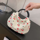 Cream canvas cherry print handbag with black circular handle