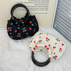 Two cherry print drawstring handbags with black circular handles on white fabric.