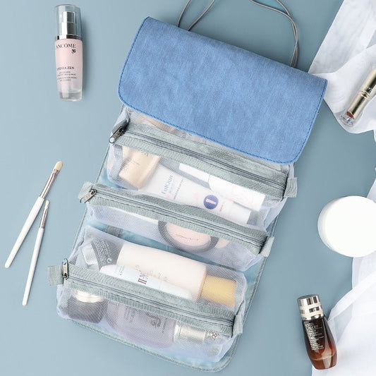 Blue mesh travel toiletry bag organizer filled with skincare and cosmetic bottles.