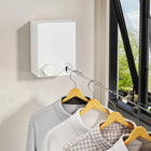 Wall-mounted retractable clothes drying rack with shirts on wooden hangers