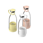 Three colorful portable electric juicers in yellow, white, and pink.