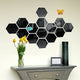 Hexagonal black mirror wall decor arranged in a honeycomb pattern above a console table.