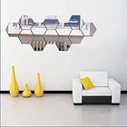 Modern hexagonal geometric wall mirror decor in a minimalist living room setting.