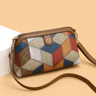 Multicolor patchwork crossbody bag with brown leather strap and gold hardware.