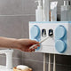 Hand placing a toothbrush into a white and blue wall-mounted bathroom organizer holder.