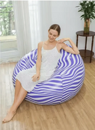 Woman relaxing on a purple and white striped bean bag chair in a bright living room