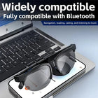Black Bluetooth smart sunglasses resting on a smartphone and laptop keyboard.