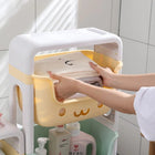 Person placing a folded white towel into a yellow cute character storage bin.