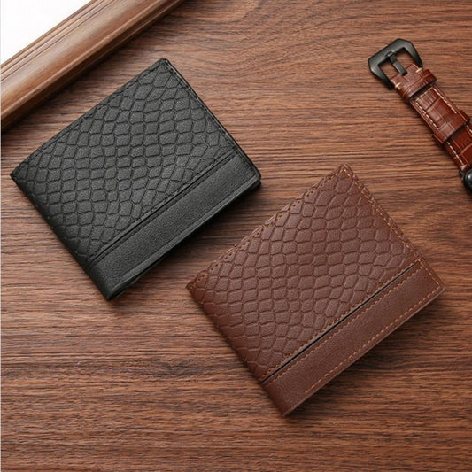 Black and brown textured faux leather slim wallets on a wooden surface with a watch.