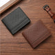 Black and brown textured faux leather slim wallets on a wooden surface with a watch.