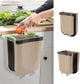 Wall-mounted beige kitchen trash can with a removable liner for food waste disposal.