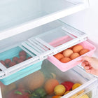 Plastic hanging refrigerator organizers holding fresh eggs and strawberries in a fridge.